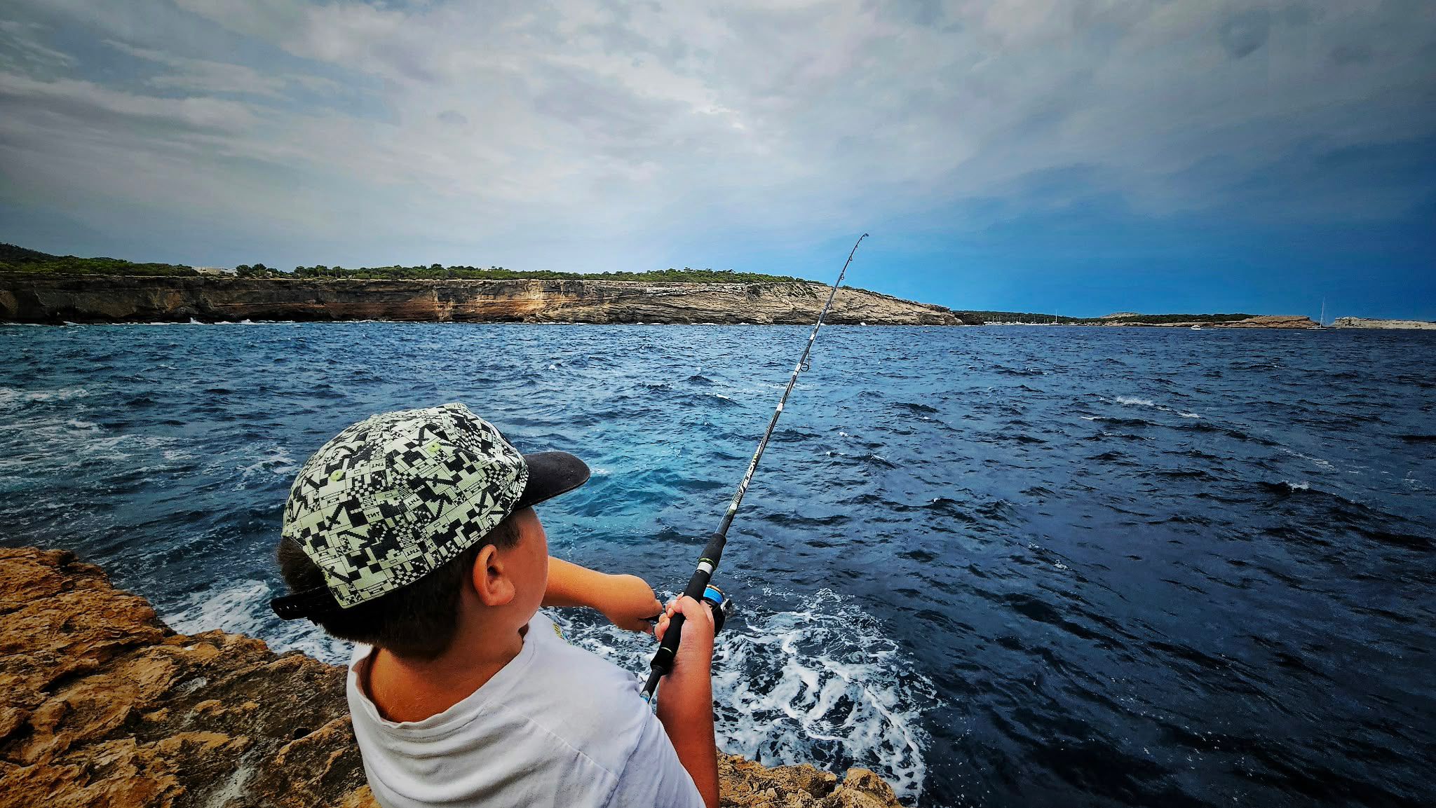 Lance de shore jigging desde la roca con el mar rompiendo, técnica para pescar serviola desde costa